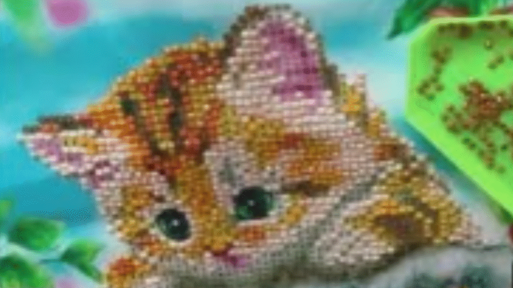 gatito hecho en punto diamante colgado de una rama